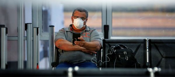 Un hombre con una mascarilla debido al coronavirus en el aeropuerto en El Salvador - Sputnik Mundo