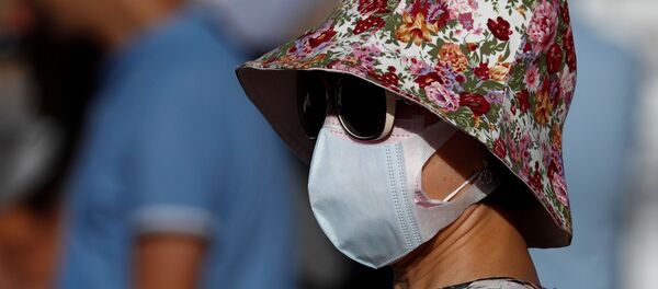 Una mujer lleva una mascarilla - Sputnik Mundo