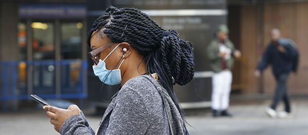 Una mujer lleva una mascarilla - Sputnik Mundo