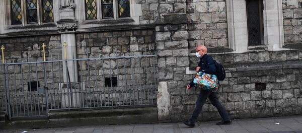 Un hombre en mascarillas en Londres - Sputnik Mundo