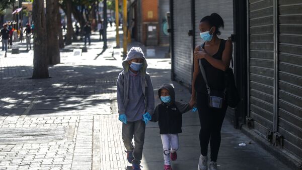 Niños con tapaboca caminando con una mujer - Sputnik Mundo