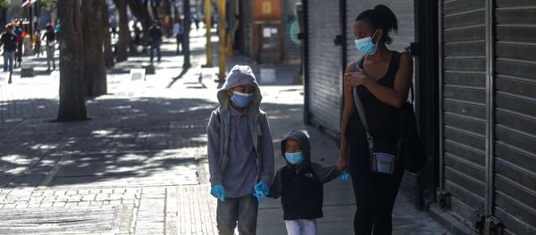 Niños con tapaboca caminando con una mujer - Sputnik Mundo