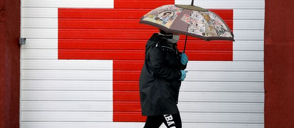 Una persona cerca de la oficina de la Cruz Roja en Oviedo, España - Sputnik Mundo