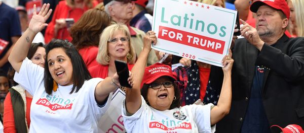 Una partidaria de Donald Trump con una pancarta que dice Latinos a favor de Trump - Sputnik Mundo