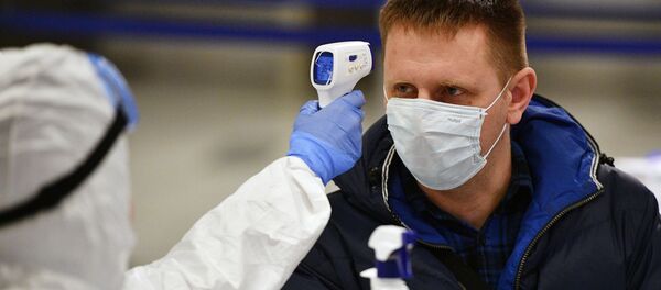 Un médico tomando la temperatura a un hombre con mascarilla durante brote de coronavirus en Moscú, Rusia Un médico tomando la temperatura a un hombre con mascarilla durante brote de coronavirus en Moscú, Rusia - Sputnik Mundo