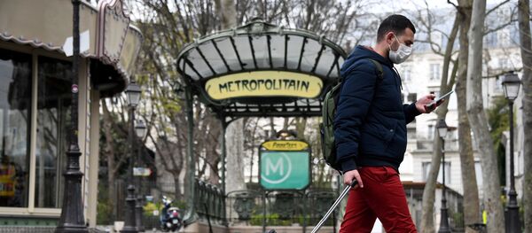 Un hombre se protege frente al coronavirus en París - Sputnik Mundo