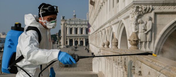 Un hombre desinfectando las calles de Venecia, Italia - Sputnik Mundo