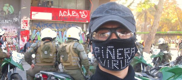 Manifestante con barbijo contra Piñera - Sputnik Mundo