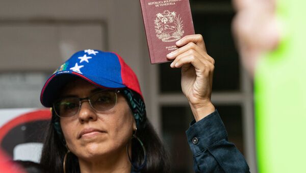 Una mujer sostiene en sus manos un pasaporte venezolano Una mujer sostiene en sus manos un pasaporte venezolano - Sputnik Mundo