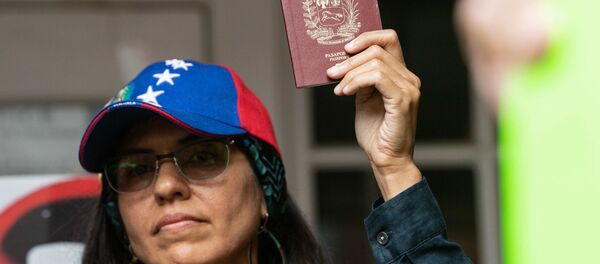 Una mujer sostiene en sus manos un pasaporte venezolano Una mujer sostiene en sus manos un pasaporte venezolano - Sputnik Mundo