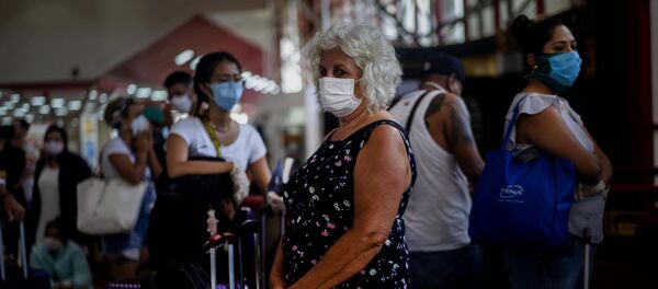 Una mujer con mascarilla - Sputnik Mundo