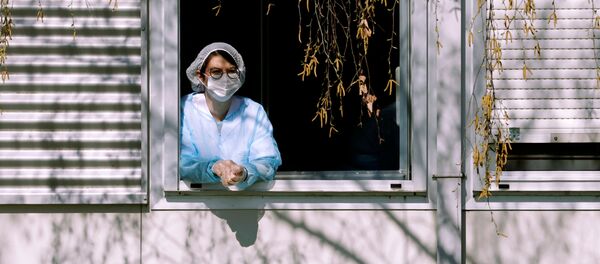 Una mujer con mascarilla - Sputnik Mundo