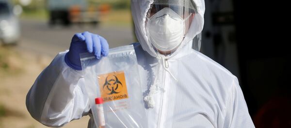 Un médico con un test de coronavirus - Sputnik Mundo