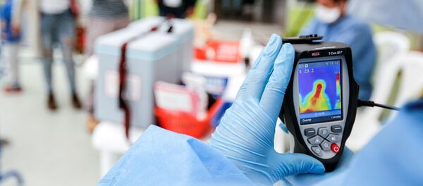 El personal médico con un escáner térmico en Ecuador - Sputnik Mundo