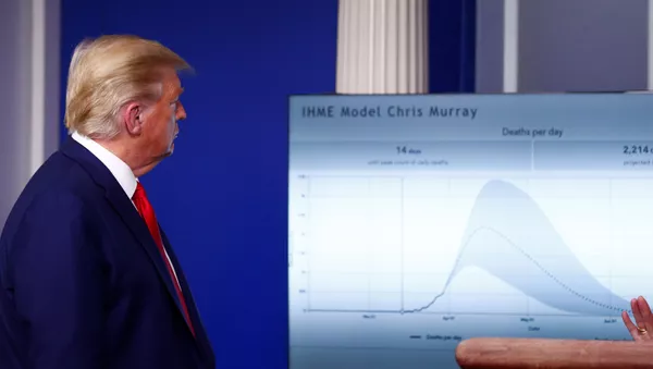 El presidente de EEUU Donald Trump observando una gráfica con muertes por COVID-19