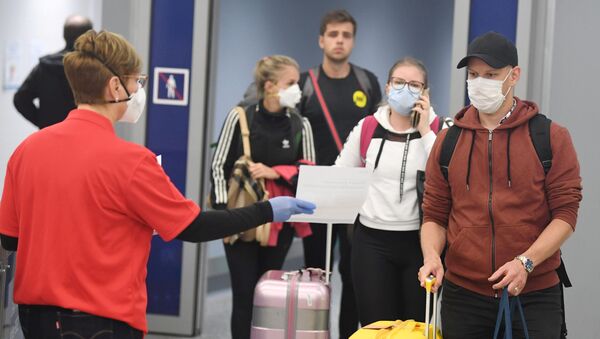Unos turistas con mascarillas en un aeropuerto - Sputnik Mundo