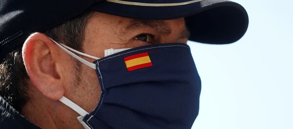Una persona con una mascarilla que lleva la bandera esañola Una persona con una mascarilla que lleva la bandera esañola - Sputnik Mundo