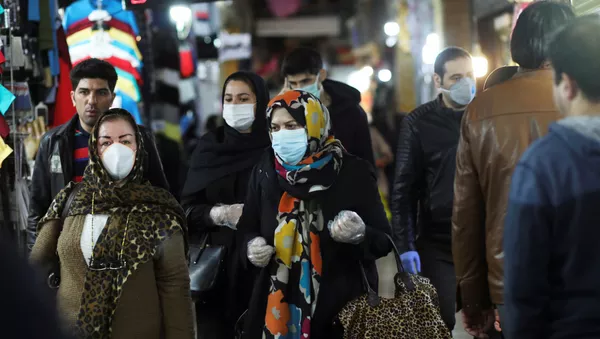 Personas usan mascarillas y guantes protectores mientras caminan en Teherán, Irán