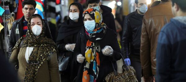 Personas usan mascarillas y guantes protectores mientras caminan en Teherán, Irán - Sputnik Mundo