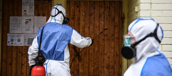 Desinfección de la entrada de un bloque de pisos en Moscú, Rusia - Sputnik Mundo