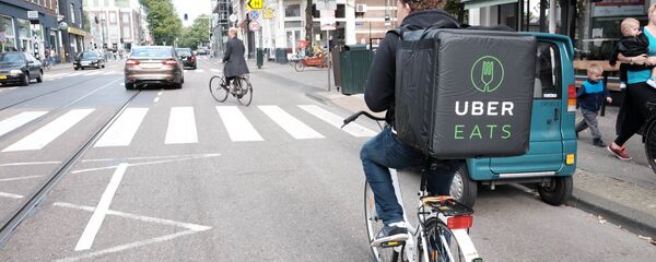 Un repartidor de comida de Uber Eats Un repartidor de comida de Uber Eats - Sputnik Mundo