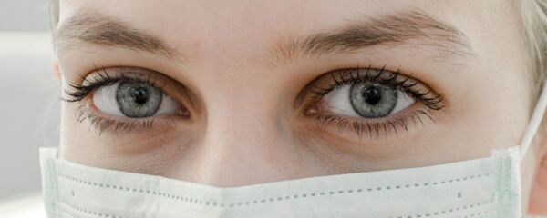 Una mujer con una mascarilla (archivo) - Sputnik Mundo