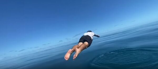 Un pescador se lanza al agua por su caña de pescar - Sputnik Mundo