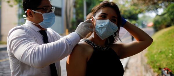 Un chico y una chica con mascarillas durante el brote del coronavirus en El Salvador Un chico y una chica con mascarillas durante el brote del coronavirus en El Salvador - Sputnik Mundo