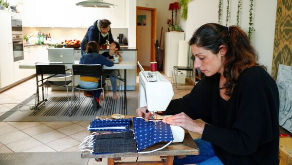 Una mujer cosiendo mascarillas - Sputnik Mundo