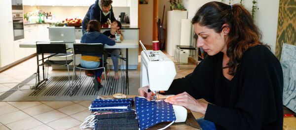 Una mujer cosiendo mascarillas - Sputnik Mundo