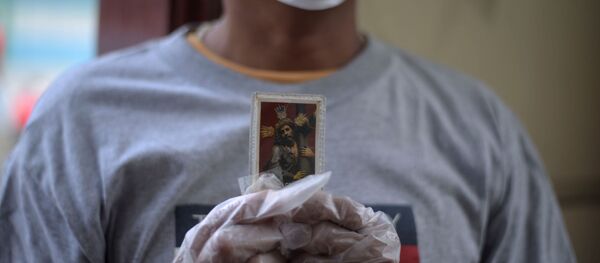 Una persona con una imagen de Jesucristo en Ecuador - Sputnik Mundo