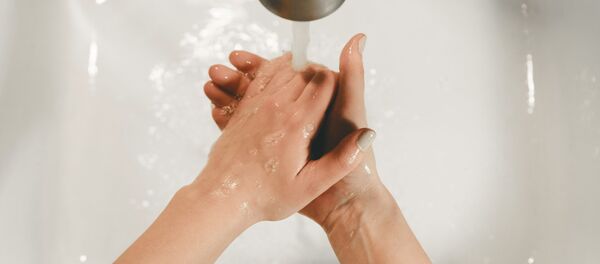 Una persona se lava las manos - Sputnik Mundo