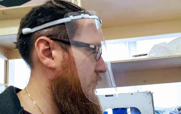 Uno de los especialistas prueba la visera protectora - Sputnik Mundo