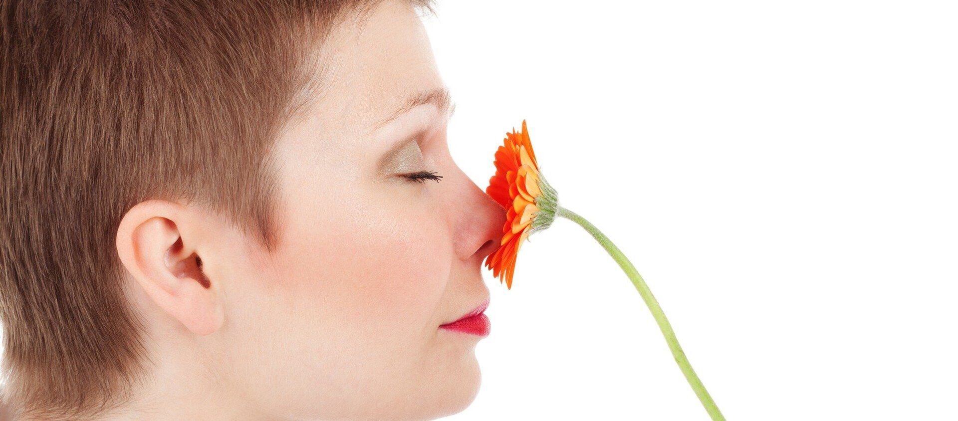 Una mujer huele una una flor - Sputnik Mundo, 1920, 15.04.2020