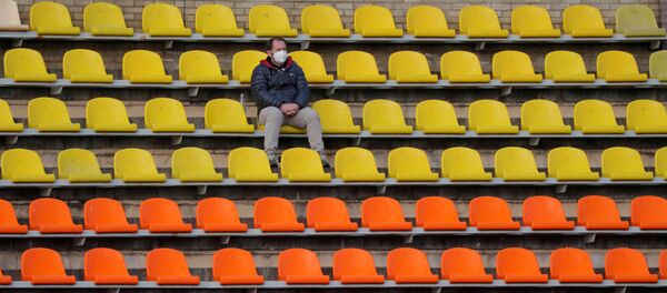 Un hombre en mascarilla en un estadio vacío - Sputnik Mundo