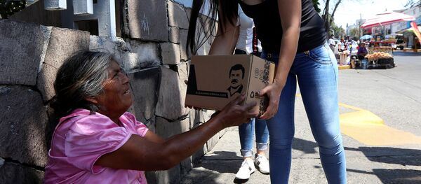 Una mujer entregando una  'Chapo despensa 701'  - Sputnik Mundo