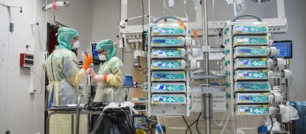Dos sanitarias con una máquina de ECMO en el Hospital Karolinska de Estocolmo (Suecia) - Sputnik Mundo