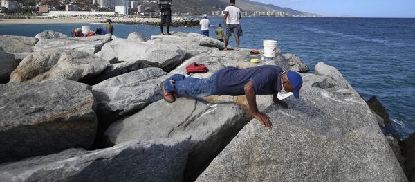 Un hombre en mascarilla entrena en la playa Los Corales en La Guaira, Venezuela - Sputnik Mundo