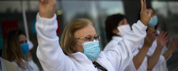 Trabajadora médica hace una señal de victoria en un gesto en apoyo al personal que está trabajando para vencer el brote del coronavirus SARS-CoV-2 en el hospital Puerta de Hierro en Majadahonda (España) - Sputnik Mundo