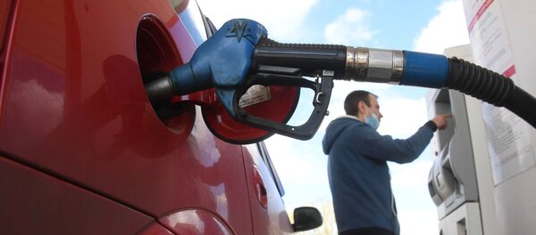 Un hombre tanquea el coche en una gasolinera Un hombre tanquea el coche en una gasolinera - Sputnik Mundo