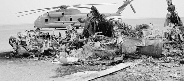Restos de un helicóptero estadounidense quemado frente a un helicóptero abandonado en Irán, el 27 de abril de 1980 - Sputnik Mundo