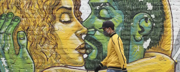 Un hombre en mascarilla pasa al lado de un muro con graffiti en Quito Un hombre en mascarilla pasa al lado de un muro con graffiti en Quito - Sputnik Mundo