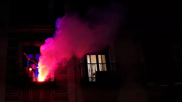 Un joven celebra el Día de la Comunidad de Madrid desde su ventana 