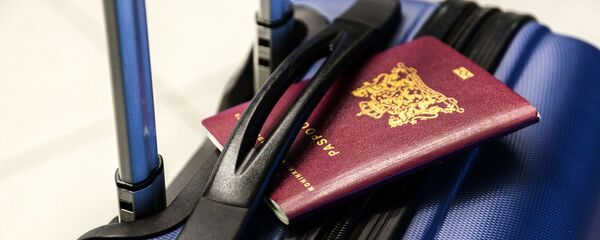 Un pasaporte y una maleta (imagen referencial) - Sputnik Mundo