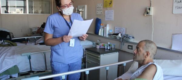 Profesional de la salud leyendo carta a paciente Profesional de la salud leyendo carta a paciente - Sputnik Mundo