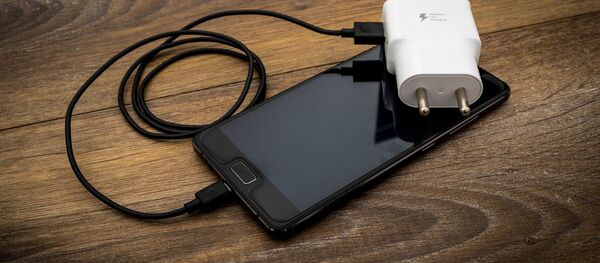 Un teléfono y un cargador - Sputnik Mundo
