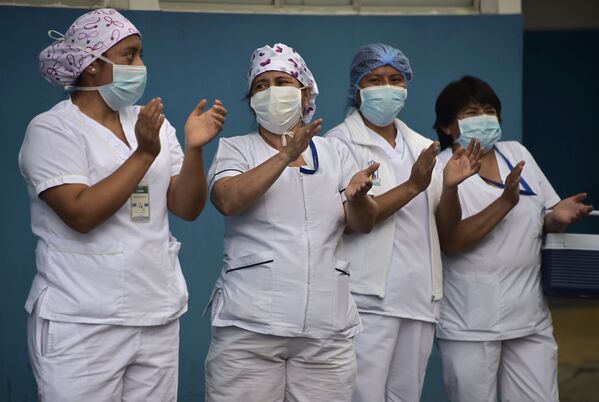 Health staff applaud as fireman Henry Garcia plays the trumpet at the emergency door of the Carlos Andrade Marin Hospital in Quito - Sputnik Mundo