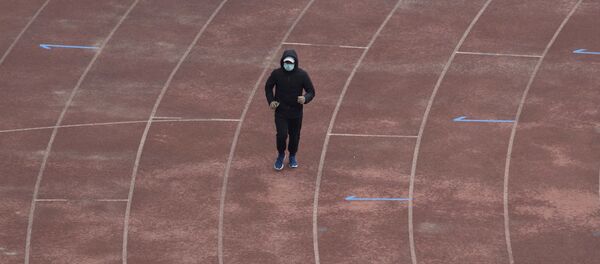 Un vecino de Wuhan corre con mascarilla - Sputnik Mundo