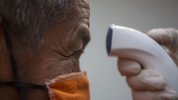 Un hombre con mascarilla haciendo una prueba por coronavirus - Sputnik Mundo