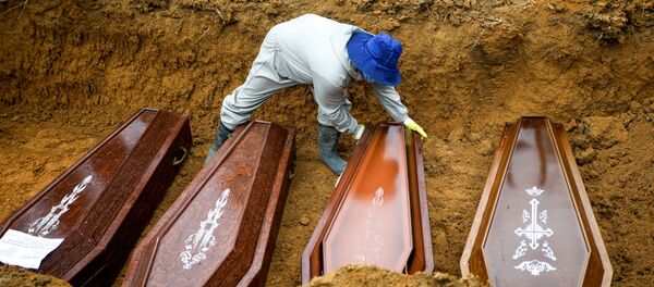 Un sepulturero trabaja durante un entierro masivo de personas que fallecieron debido al COVID-19 en Brasil - Sputnik Mundo